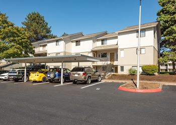 a parking lot with cars in front of an apartment building